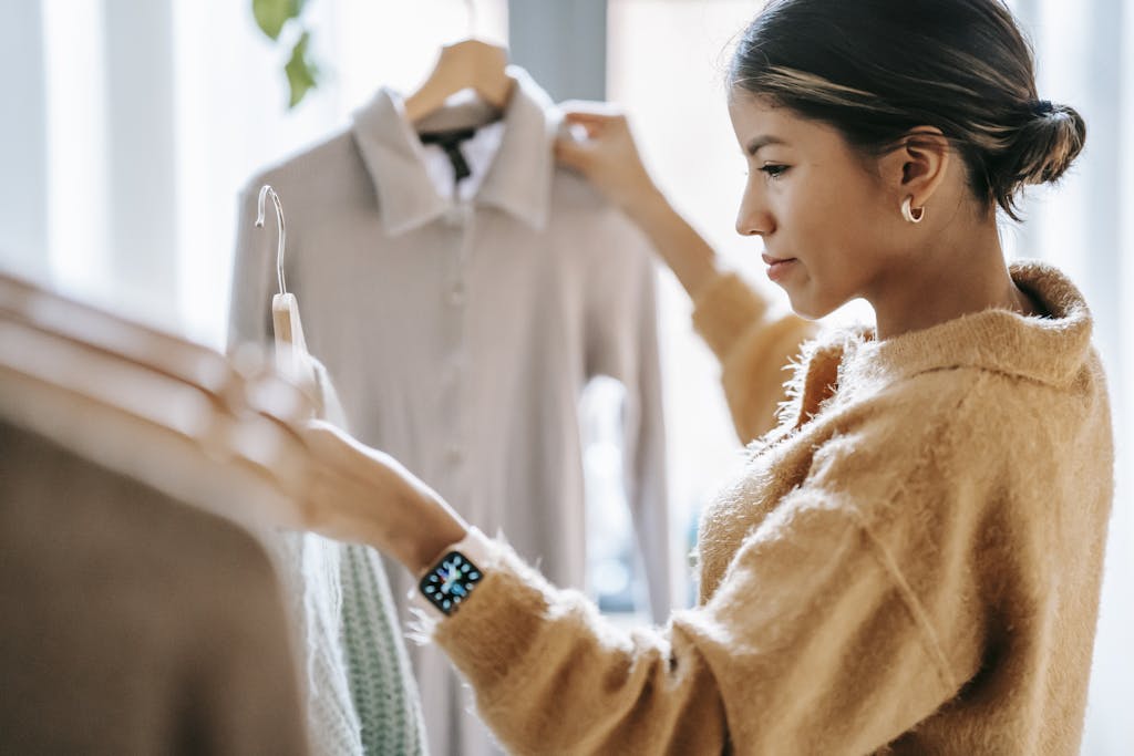 Crop-focused ethnic female in casual clothes choosing apparel from a boutique rack, exploring body-positive dress brands that offer inclusive, comfortable options.