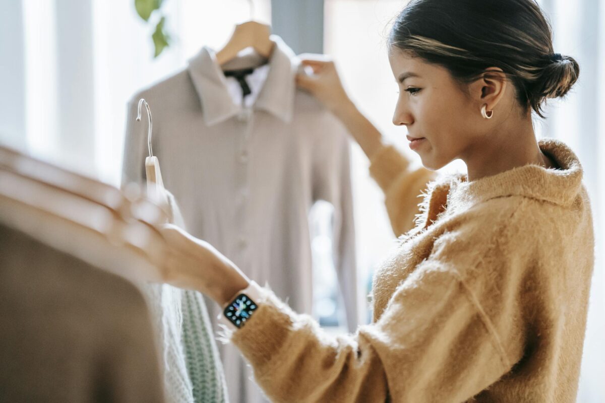 Crop-focused ethnic female in casual clothes choosing apparel from a boutique rack, exploring body-positive dress brands that offer inclusive, comfortable options.