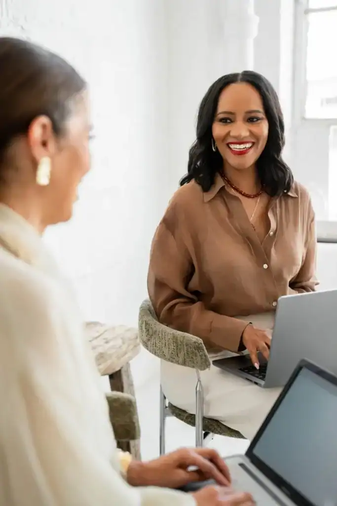 Two coworkers sharing ideas during a conversation at the office, highlighting how right-brained strengths encourage deeper connection.